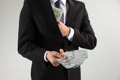 Photo of Man with dollar bills on light background, closeup