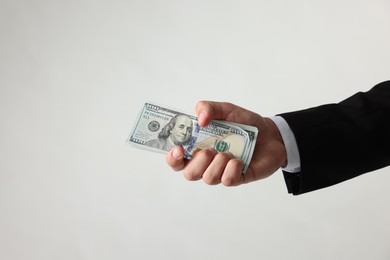 Photo of Man with dollar bills on light background, closeup