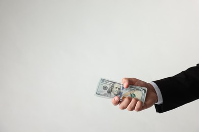 Photo of Man with dollar bills on light background, closeup. Space for text