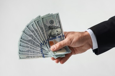 Photo of Man with dollar bills on light background, closeup