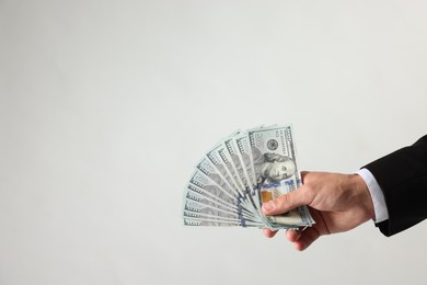 Photo of Man with dollar bills on light background, closeup. Space for text