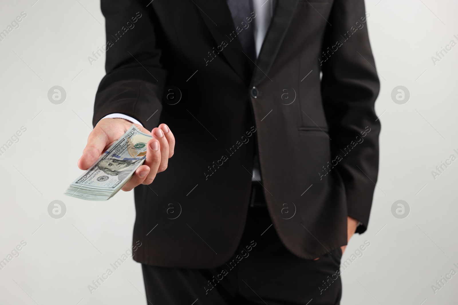 Man with dollar bills on light background, closeup Photo of Man with dollar bills on light background, closeup