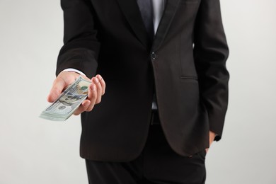 Photo of Man with dollar bills on light background, closeup
