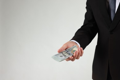 Photo of Man with dollar bills on light background, closeup. Space for text