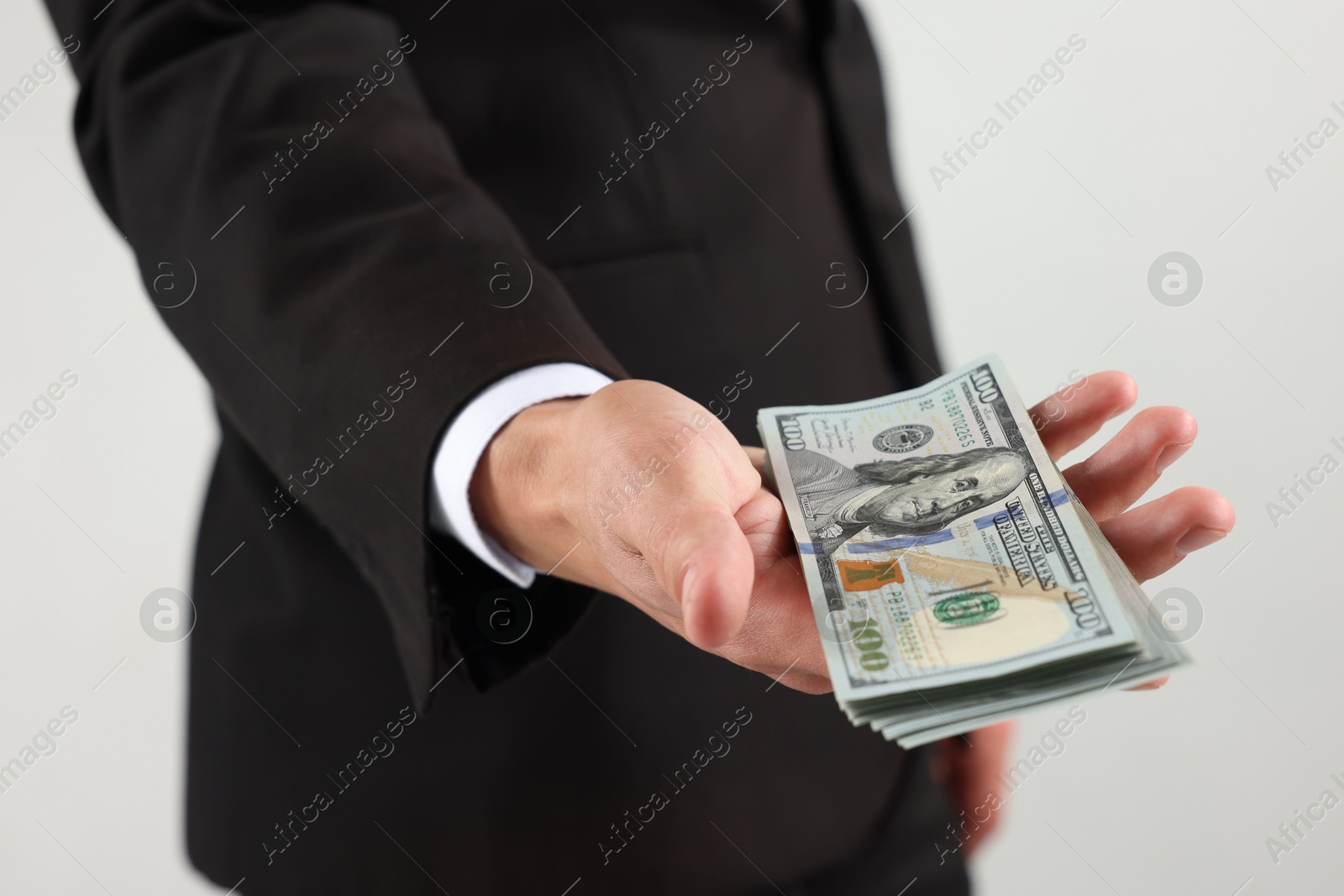 Man with dollar bills on light background, closeup Photo of Man with dollar bills on light background, closeup
