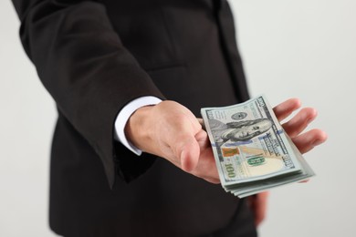 Photo of Man with dollar bills on light background, closeup