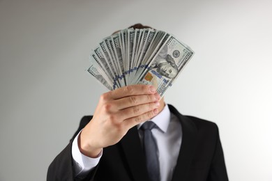Photo of Man with dollar bills on light background, closeup