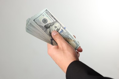 Photo of Man with dollar bills on light background, closeup