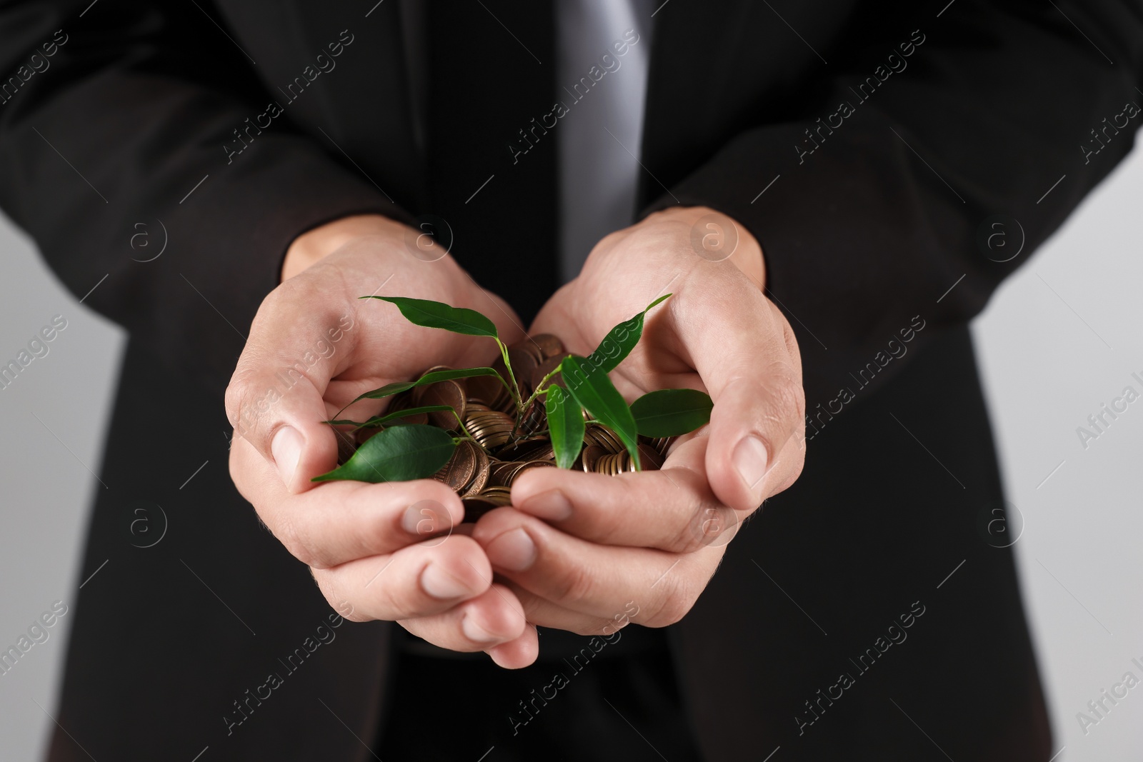 Man with coins and sprout on light background, closeup Photo of Man with coins and sprout on light background, closeup