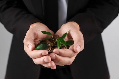 Photo of Man with coins and sprout on light background, closeup