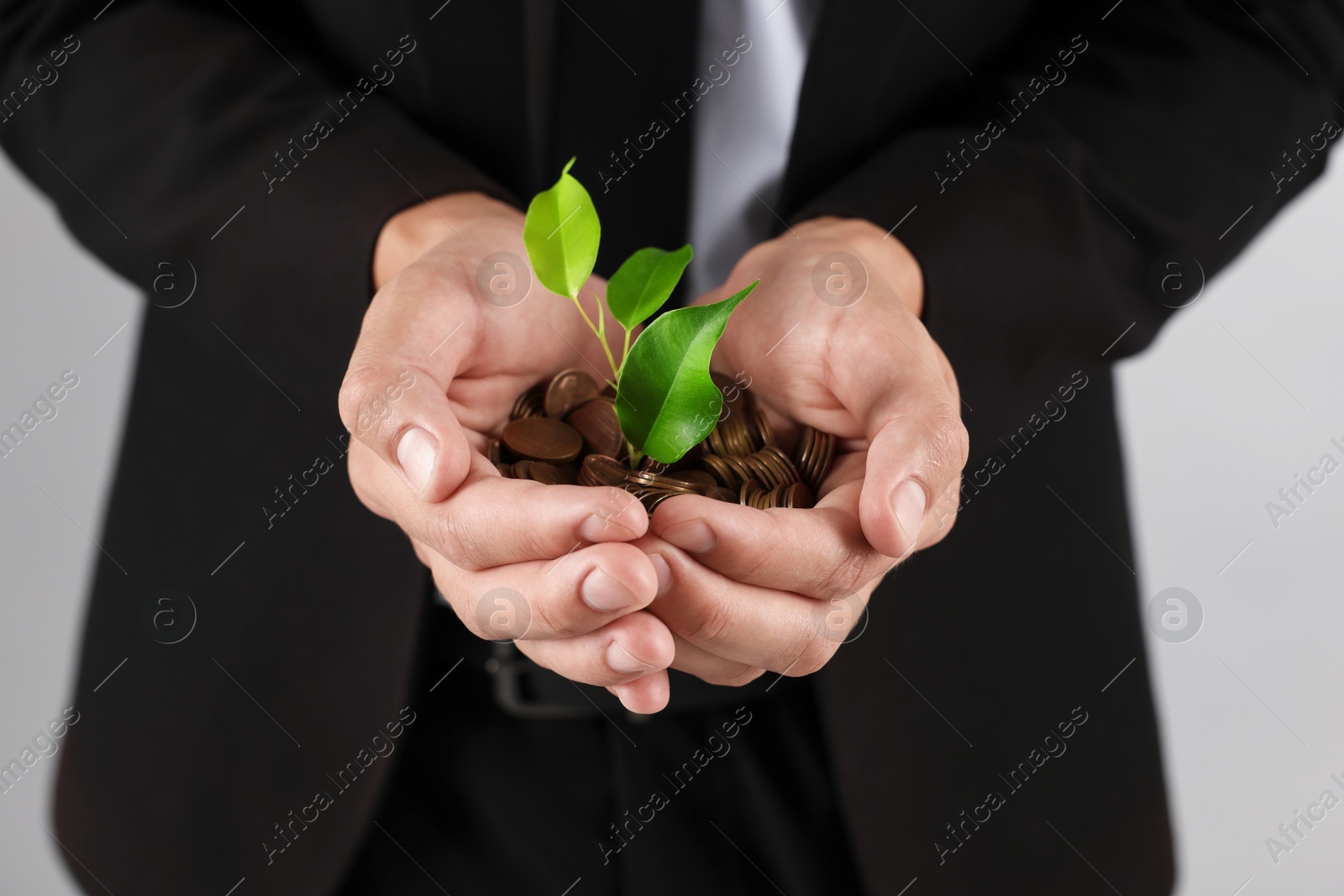 Man with coins and sprout on light background, closeup Photo of Man with coins and sprout on light background, closeup
