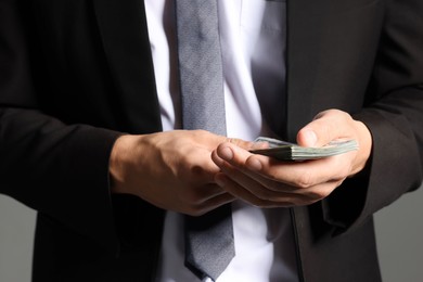 Photo of Man with dollar bills on grey background, closeup