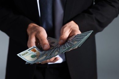 Photo of Man with dollar bills on grey background, closeup