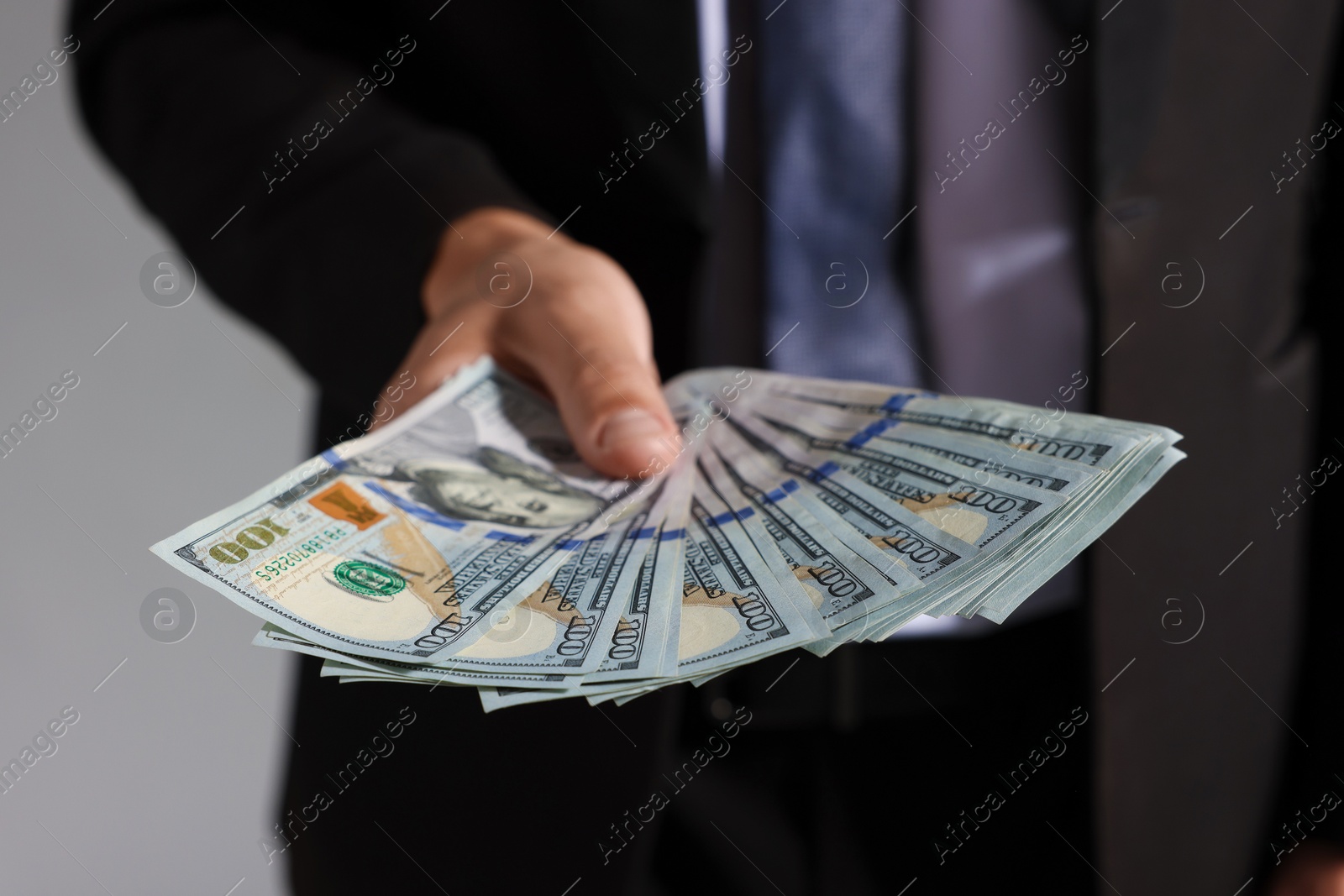 Man with dollar bills on grey background, closeup Photo of Man with dollar bills on grey background, closeup
