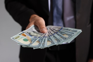 Photo of Man with dollar bills on grey background, closeup