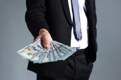 Photo of Man with dollar bills on grey background, closeup