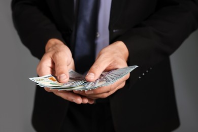 Photo of Man with dollar bills on grey background, closeup