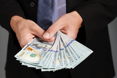 Photo of Man with dollar bills on grey background, closeup