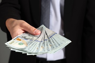 Photo of Man with dollar bills on grey background, closeup