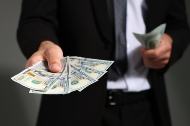 Photo of Man with dollar bills on grey background, closeup