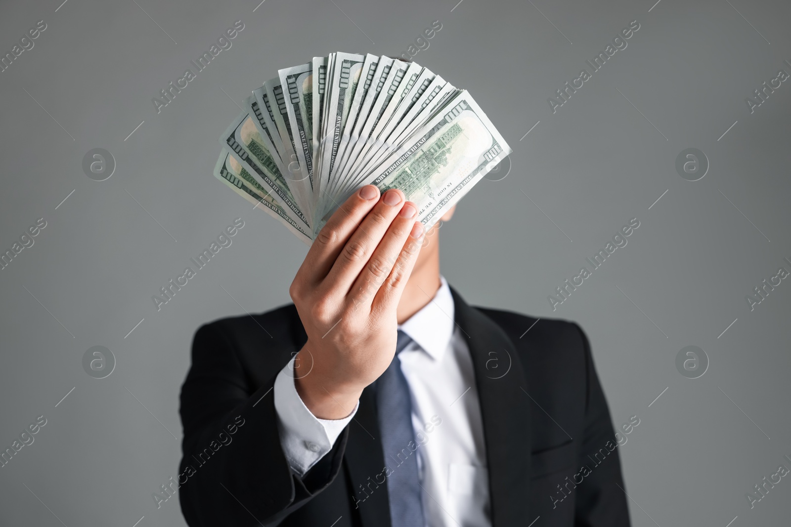 Man with dollar bills on grey background Photo of Man with dollar bills on grey background