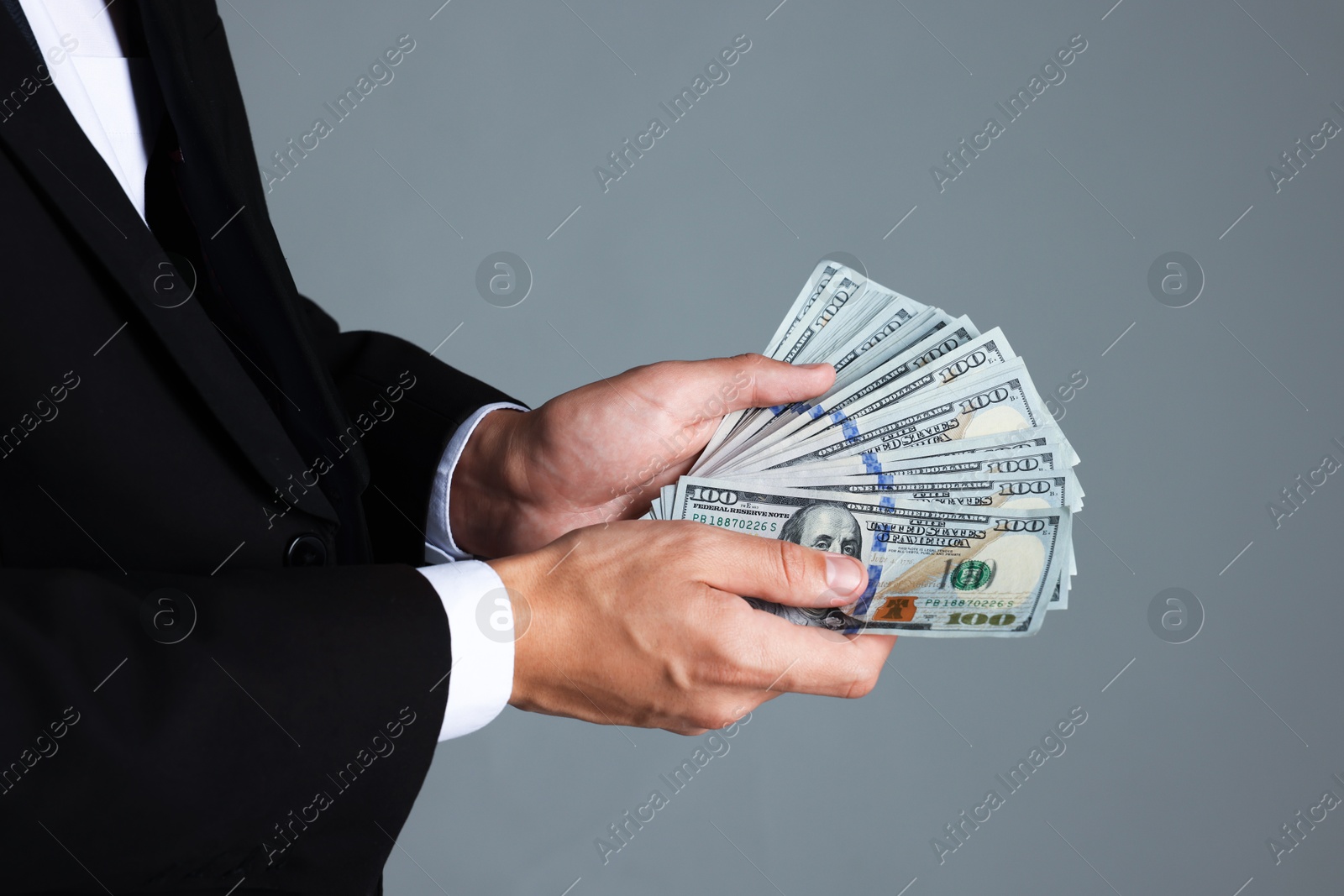 Man with dollar bills on grey background, closeup Photo of Man with dollar bills on grey background, closeup