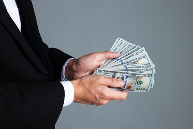 Photo of Man with dollar bills on grey background, closeup