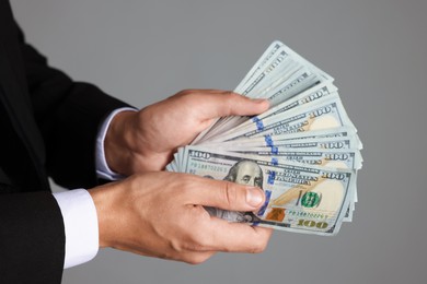 Photo of Man with dollar bills on grey background, closeup