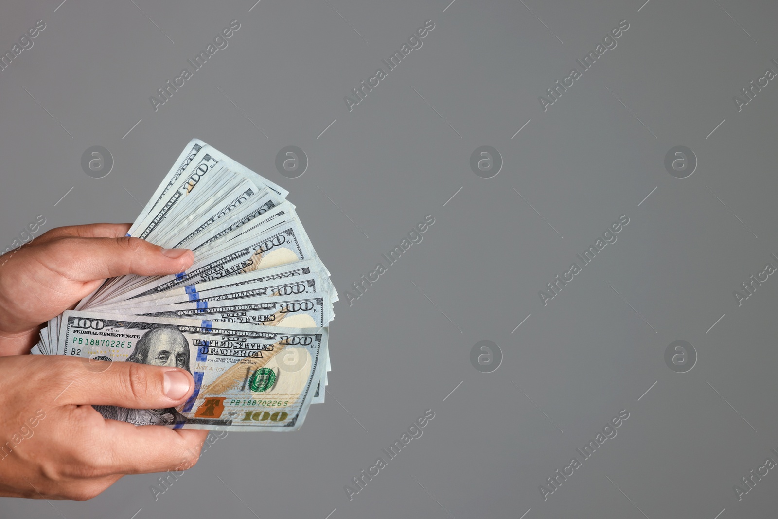 Man with dollar bills on grey background, closeup. Space for text Photo of Man with dollar bills on grey background, closeup. Space for text