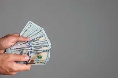 Photo of Man with dollar bills on grey background, closeup. Space for text