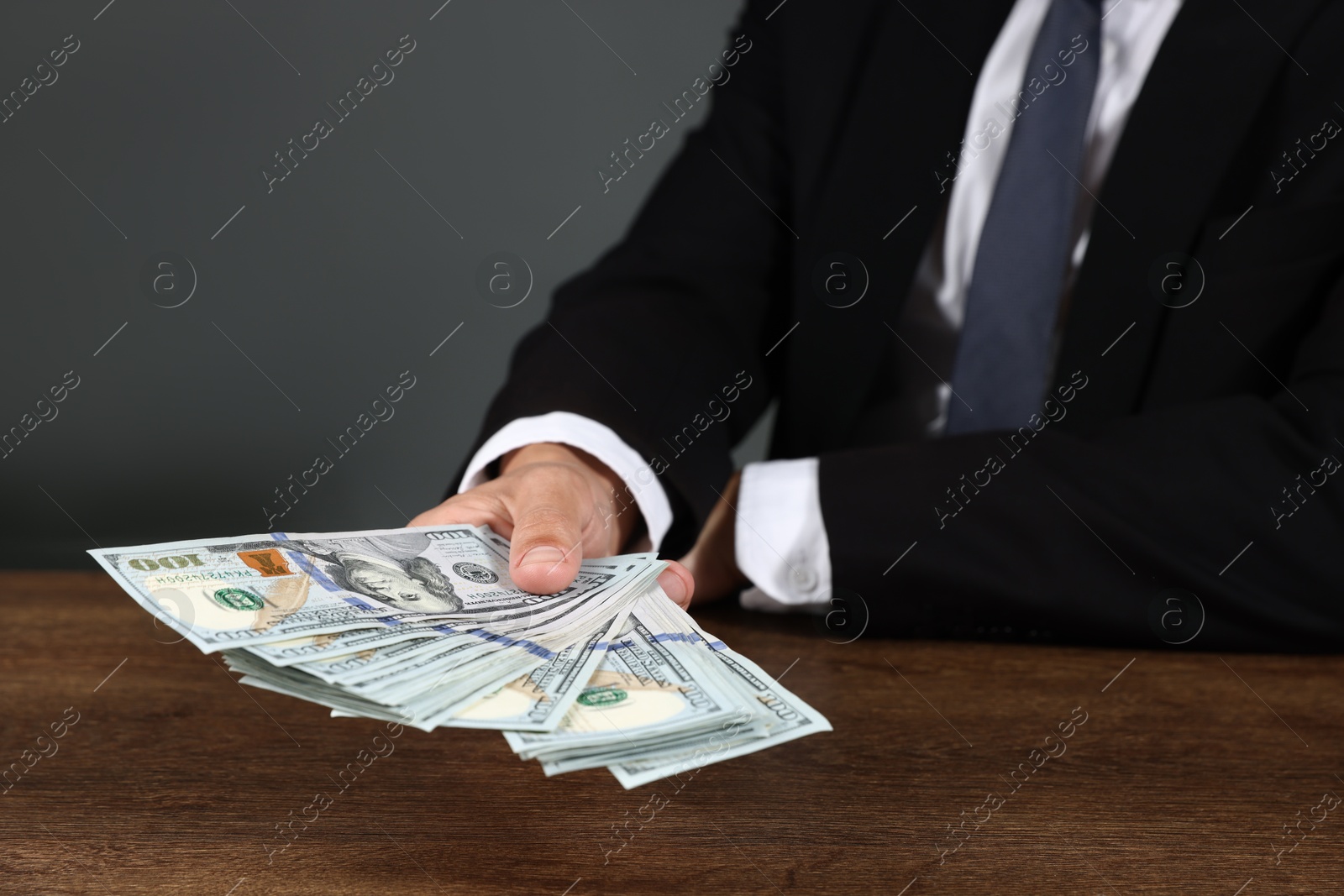 Man with dollar bills at wooden desk, closeup Photo of Man with dollar bills at wooden desk, closeup