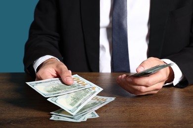 Photo of Man with dollar bills at wooden desk, closeup