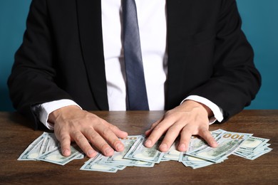 Photo of Man with dollar bills at wooden desk, closeup