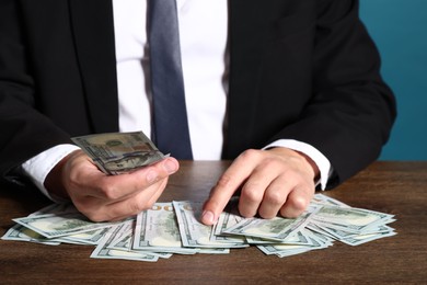 Photo of Man with dollar bills at wooden desk, closeup