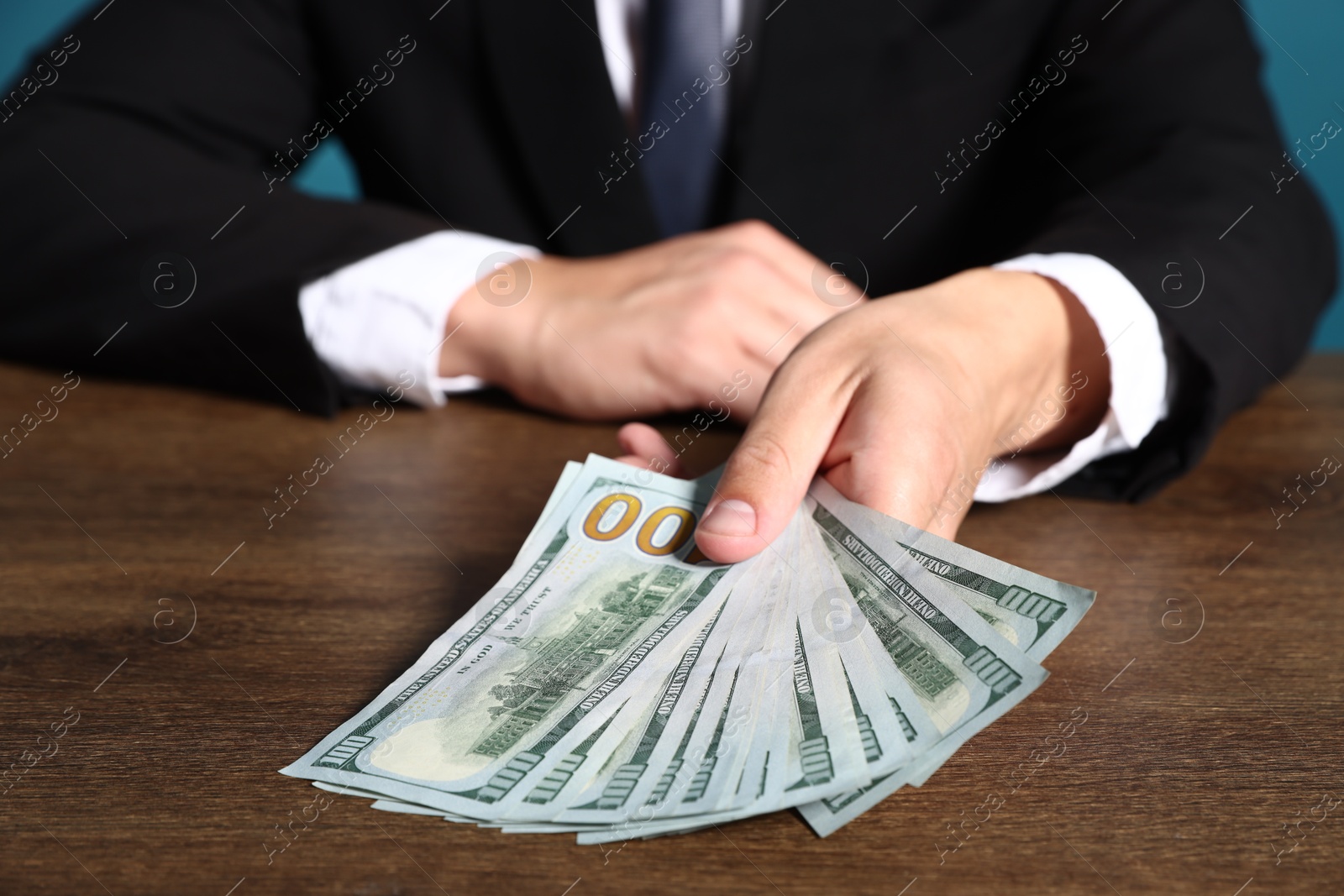 Man with dollar bills at wooden desk, closeup Photo of Man with dollar bills at wooden desk, closeup