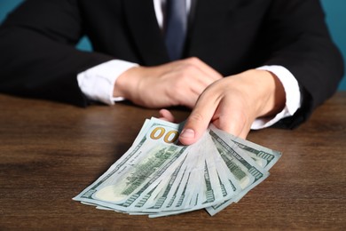 Photo of Man with dollar bills at wooden desk, closeup