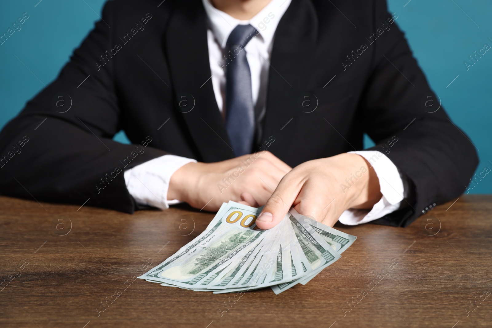 Man with dollar bills at wooden desk, closeup Photo of Man with dollar bills at wooden desk, closeup
