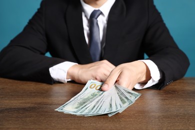Photo of Man with dollar bills at wooden desk, closeup