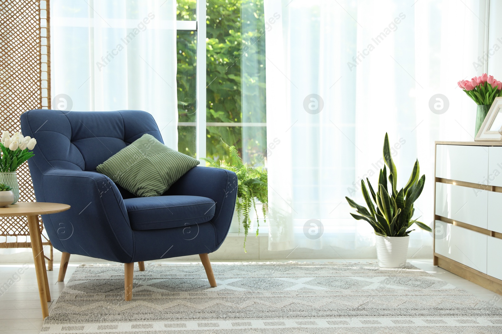Photo of Stylish blue armchair near window with curtains indoors. Interior design