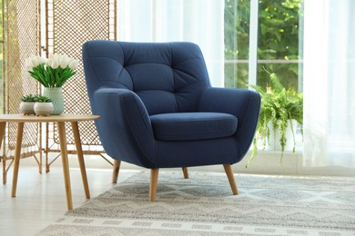 Photo of Stylish blue armchair near window with curtains indoors. Interior design