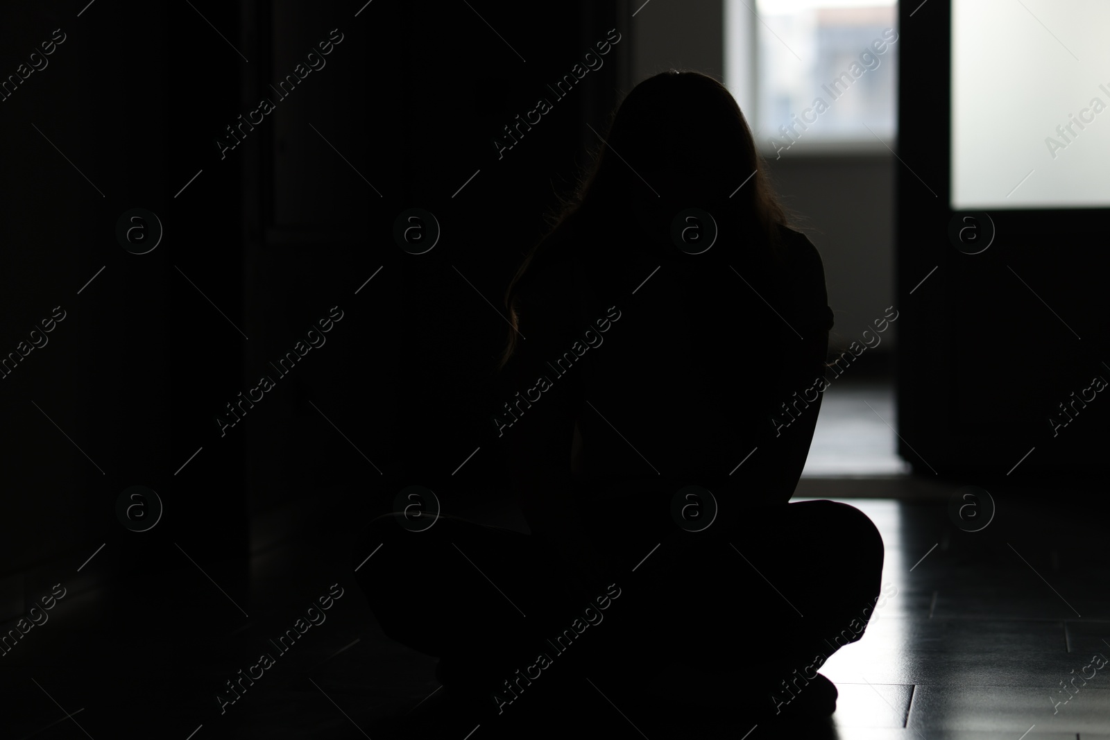 Silhouette of sad young woman at home Photo of Silhouette of sad young woman at home