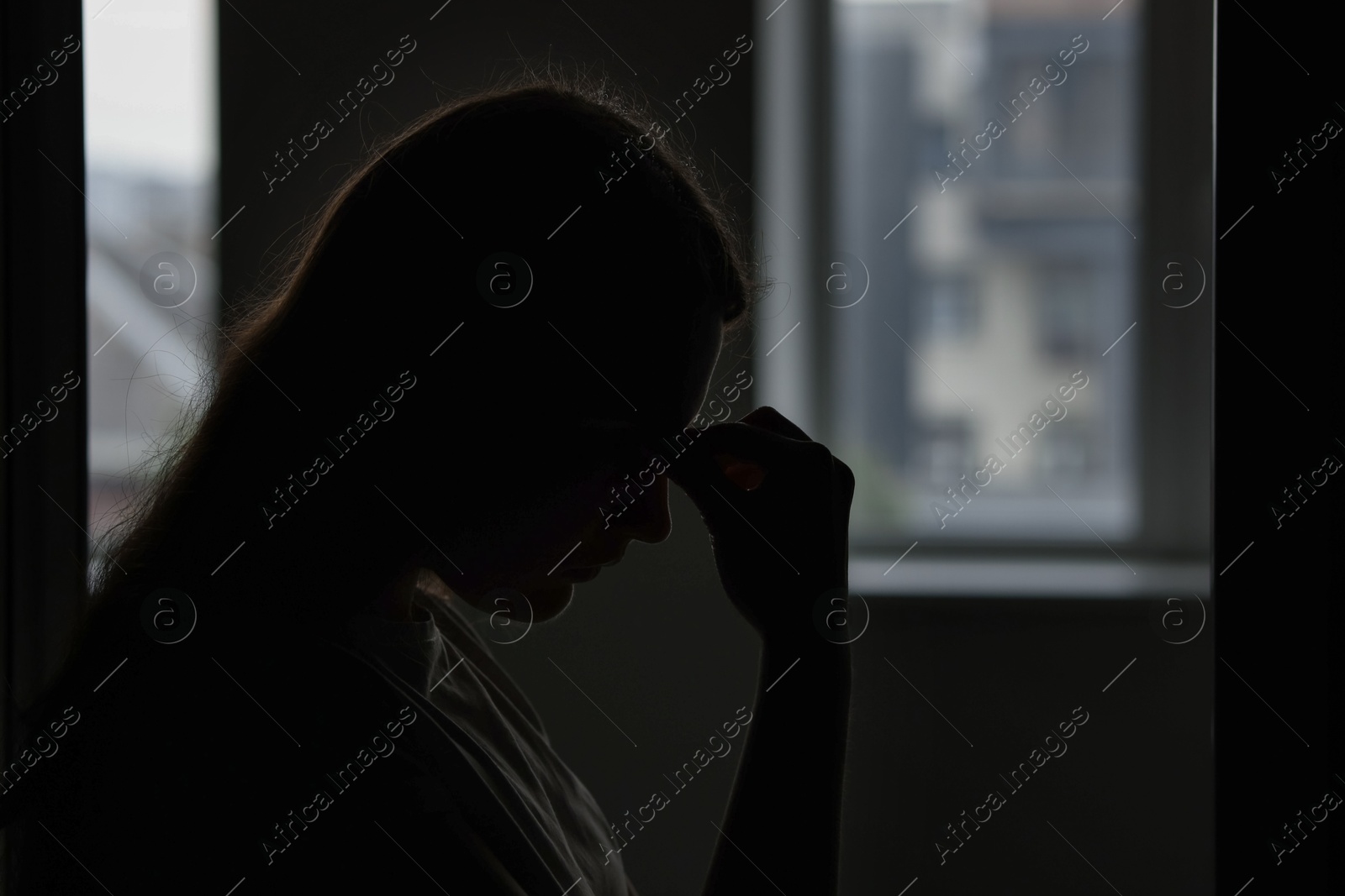 Silhouette of sad young woman at home, space for text Photo of Silhouette of sad young woman at home, space for text