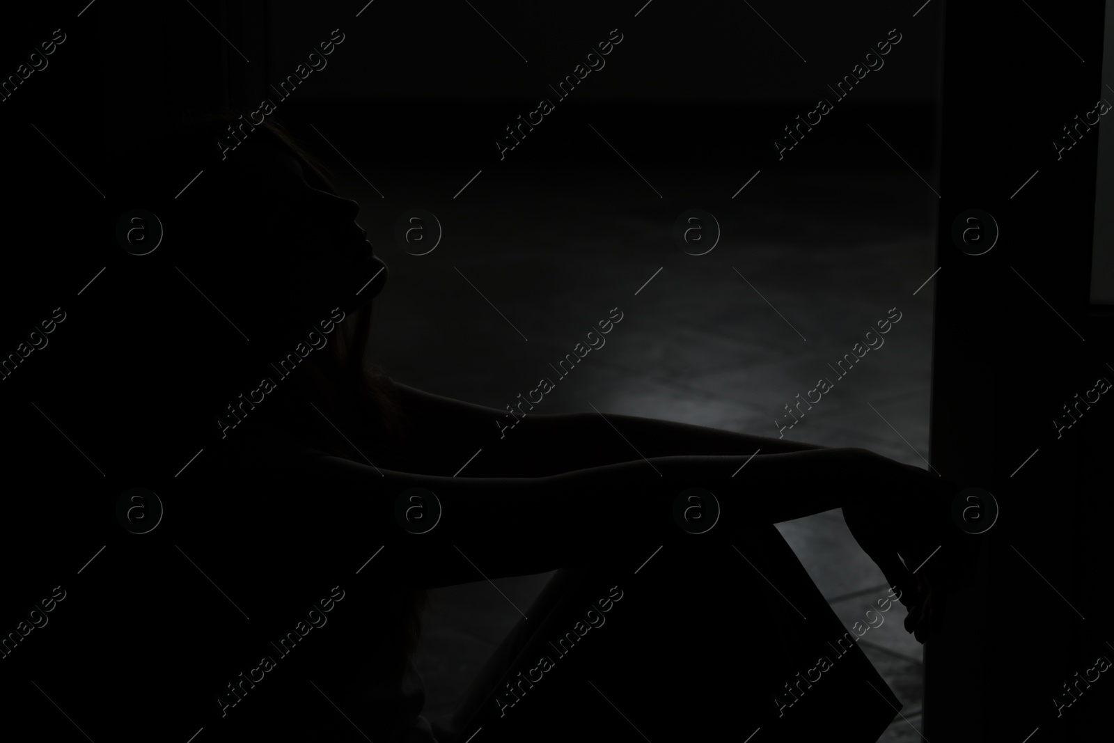 Silhouette of sad young woman at home Photo of Silhouette of sad young woman at home