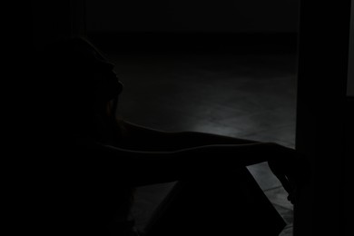 Photo of Silhouette of sad young woman at home