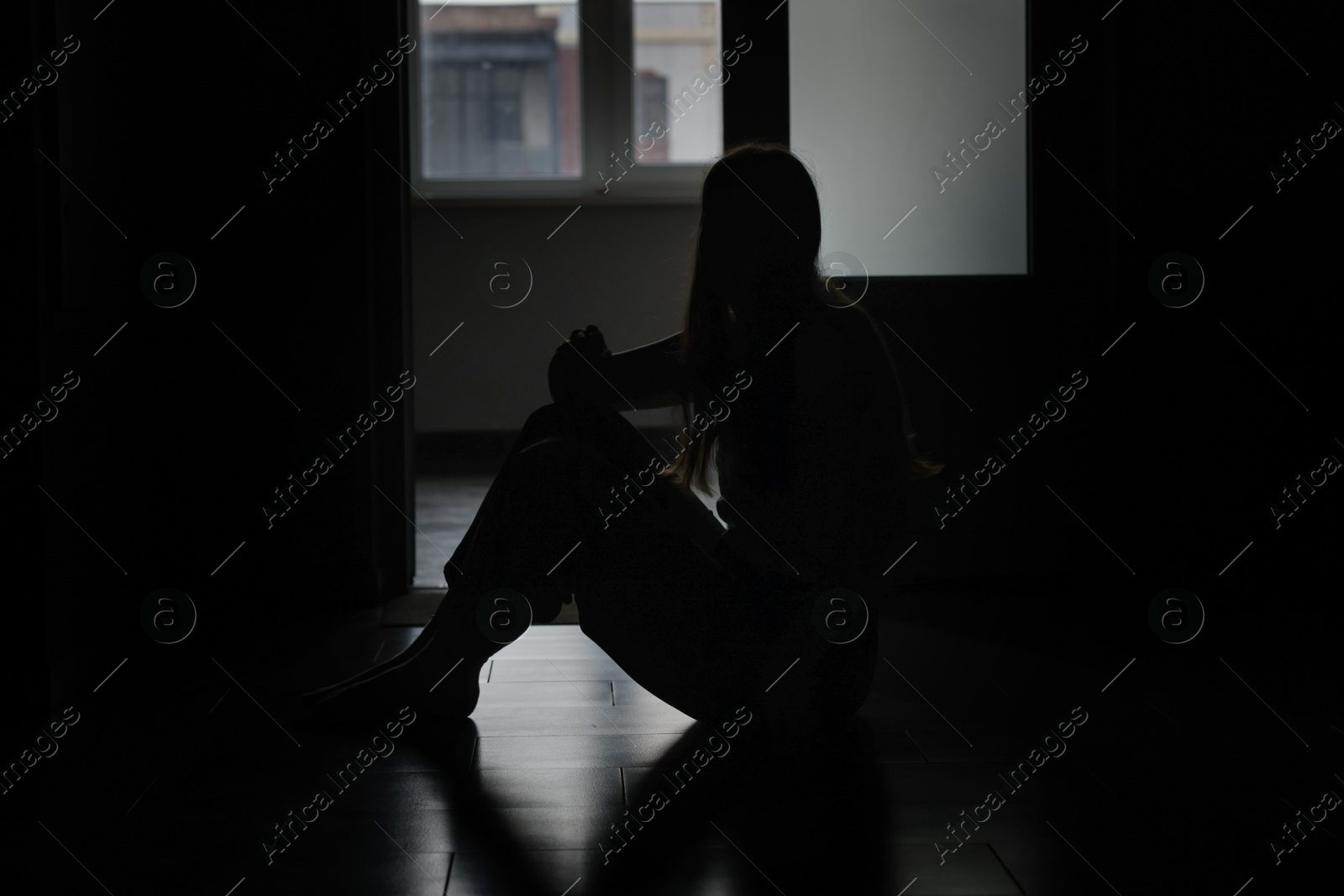Silhouette of sad young woman at home Photo of Silhouette of sad young woman at home