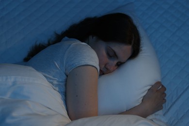 Photo of Sad young woman lying on bed at home