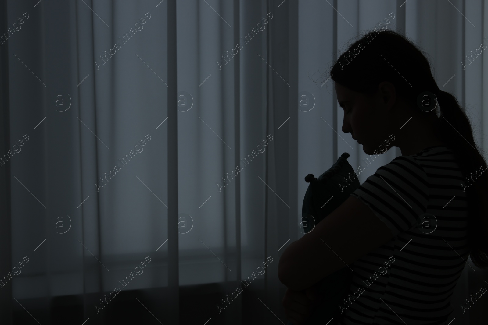 Photo of Silhouette of sad young woman at home. space for text