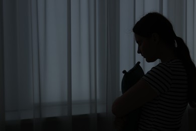 Photo of Silhouette of sad young woman at home. space for text