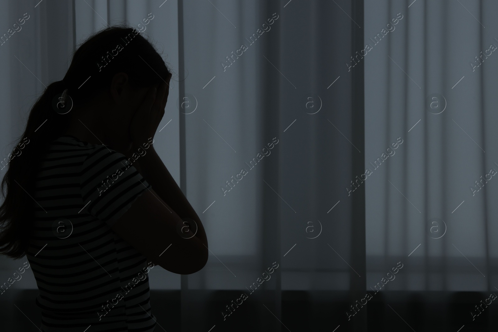 Photo of Silhouette of sad young woman at home. space for text