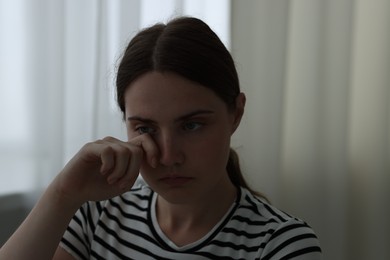 Photo of Sad young woman crying at home. Depression concept